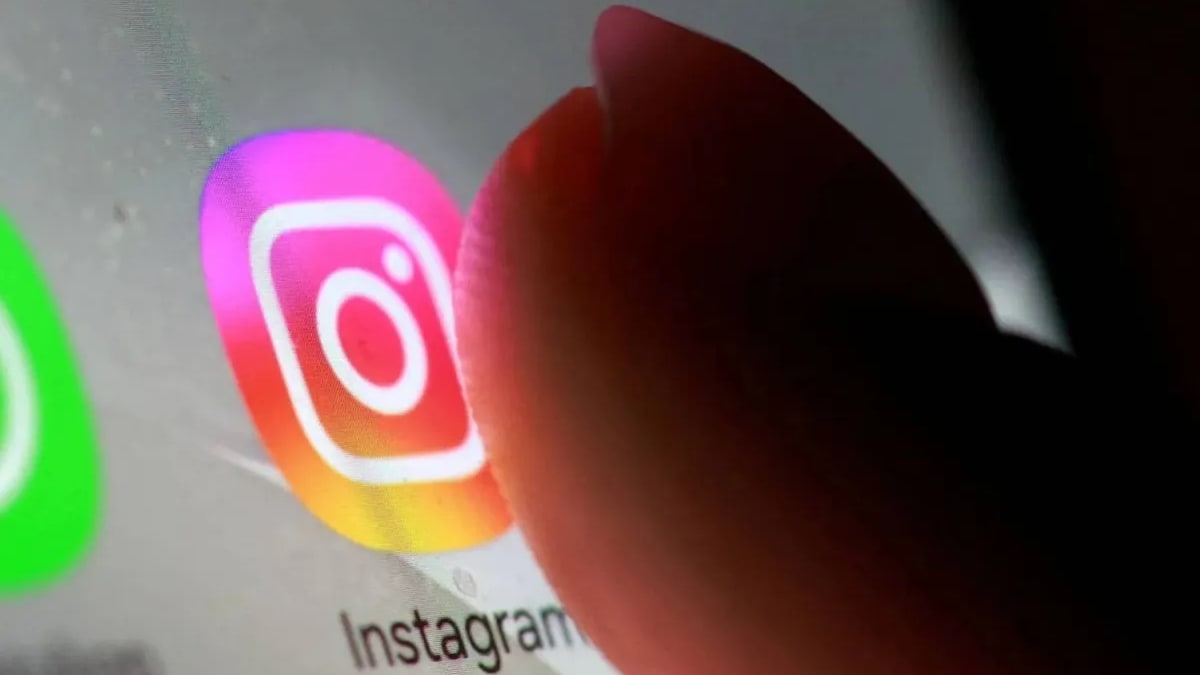 A finger about to tap the Instagram app icon on a phone screen