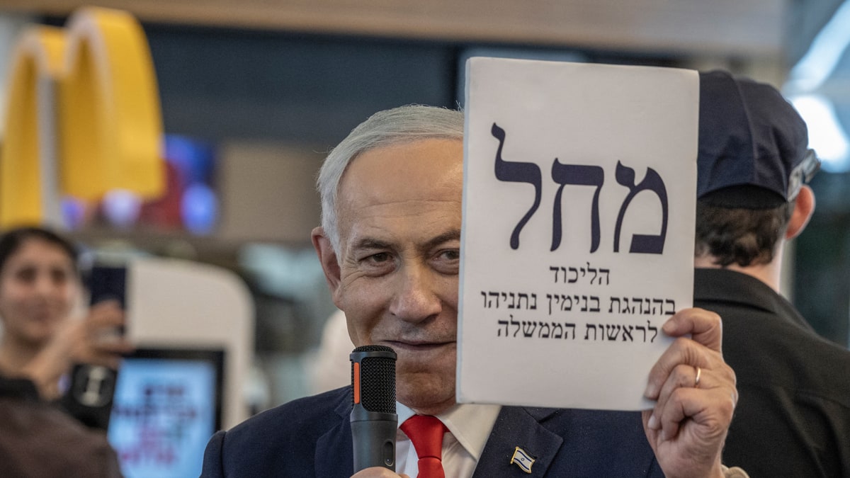 Benjamin Netanyahu holding a Likud campaign sign