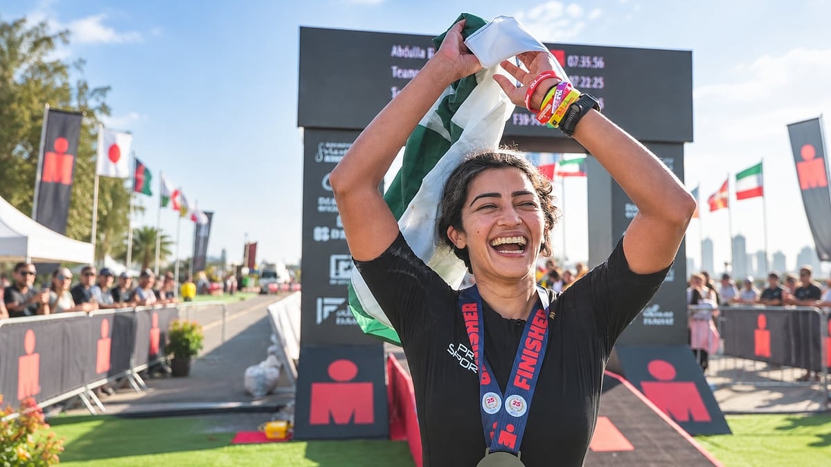 Sana Arif holding the Pakistan flag after finishing an Ironman race